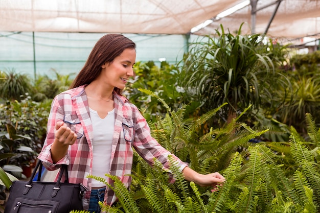 Foto gratuita mujer tocando plantas en invernadero