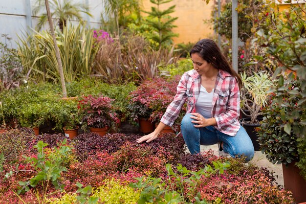 Mujer tocando plantas en invernadero