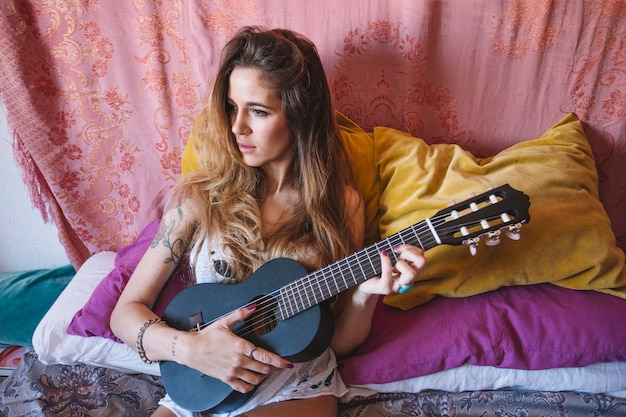 Foto gratuita mujer tocando el ukelele negro