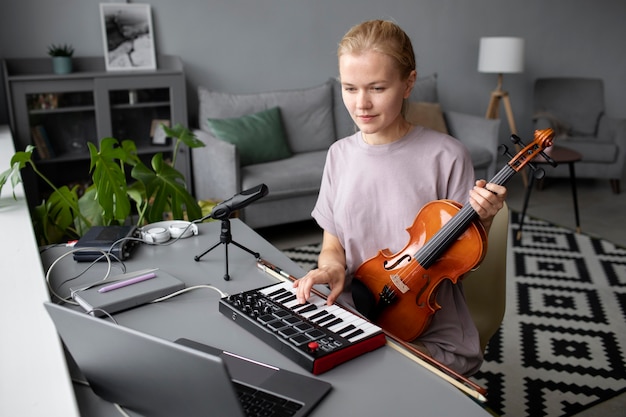 Mujer tocando el violín en la mesa de tiro medio