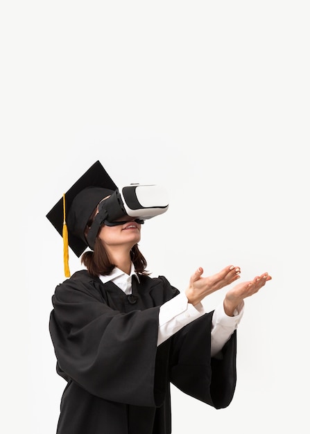 Foto gratuita mujer con toga y gorra de graduación con casco de realidad virtual