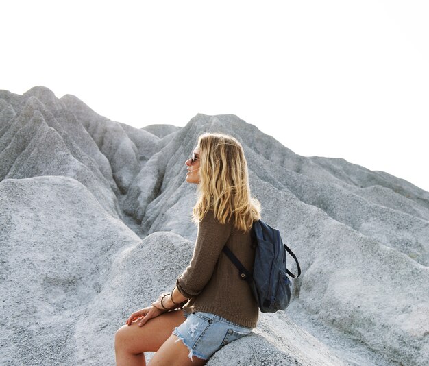 La mujer toma un descanso de ir de excursión en la roca