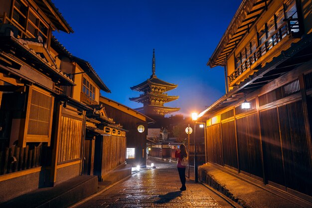 Mujer toma una foto en la Pagoda Yasaka y la calle Sannen Zaka en Kyoto, Japón.