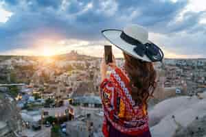 Foto gratuita mujer toma una foto con su teléfono inteligente en goreme, capadocia en turquía.