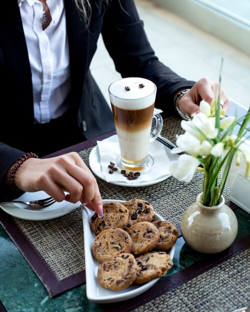 Mujer toma galletas para comer con leche