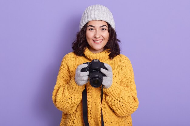 Mujer toma imágenes sosteniendo la cámara fotográfica en las manos