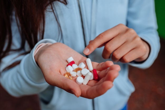 mujer toma y muestra pastillas.