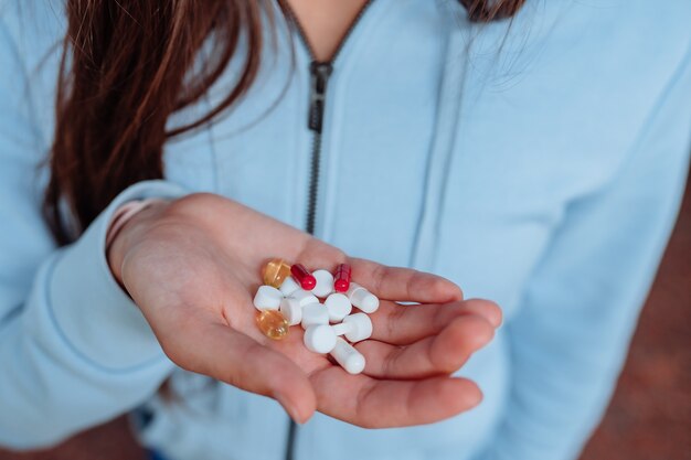 mujer toma y muestra pastillas.