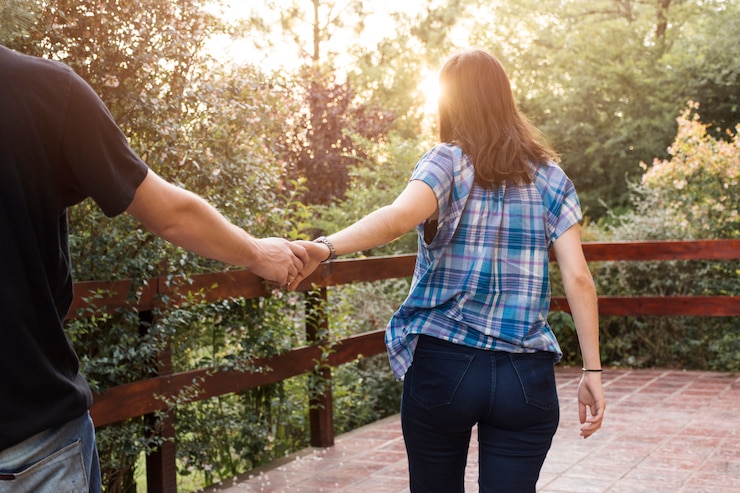 Foto gratuito mujer tomados de la mano, con, hombre, en, terraza, entre, bosque