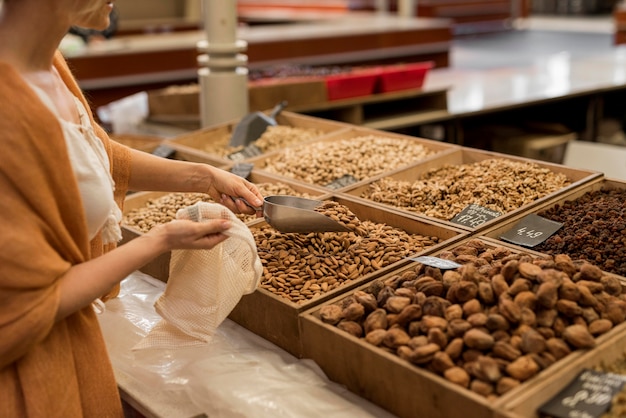 Mujer tomando alimentos secos en el mercado