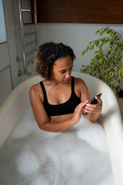 Mujer tomando baño de tiro medio