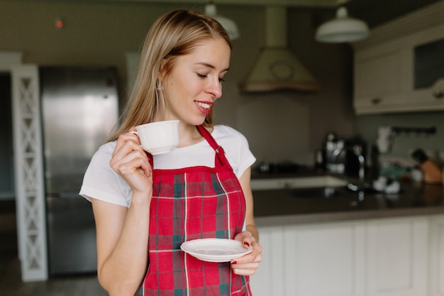 mujer tomando café en la cocina