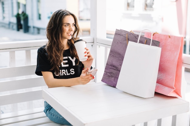 Mujer tomando café después de ir de compras