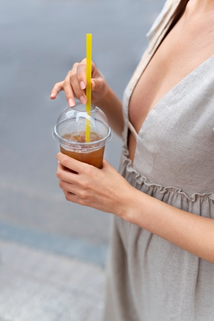 Mujer tomando un café helado afuera