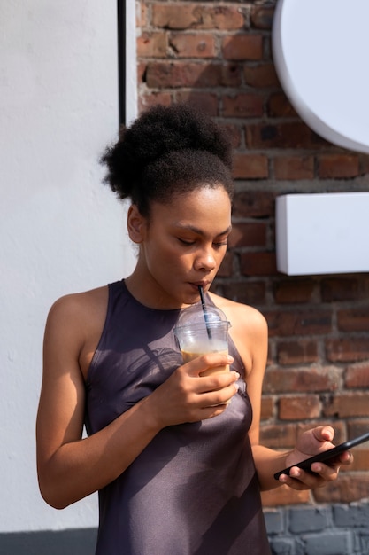 Foto gratuita mujer tomando un café helado afuera