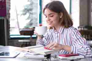 Foto gratuita mujer tomando café y leyendo