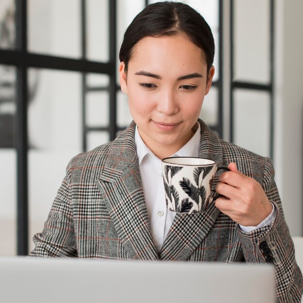 Mujer tomando café mientras trabaja