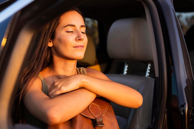 Mujer tomando el calor del sol desde su asiento de coche