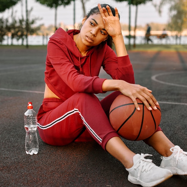 Mujer tomando un descanso después de un partido de baloncesto