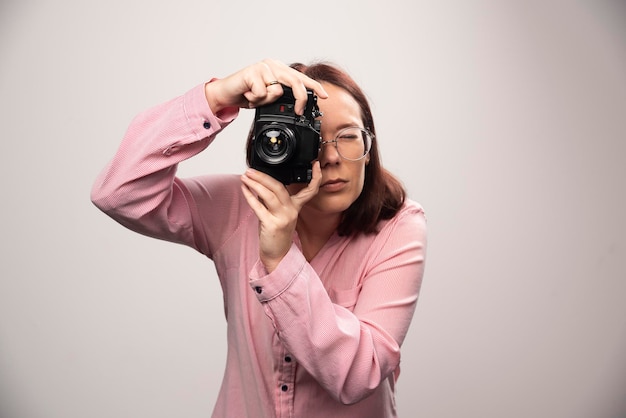Mujer tomando una foto con cámara en blanco. Foto de alta calidad