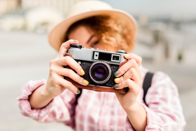 Mujer tomando una foto con una cámara mientras viaja