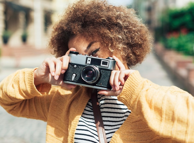 Foto gratuita mujer tomando una foto con una cámara