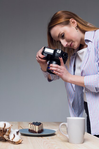 Mujer tomando una foto de comida con cámara profesional