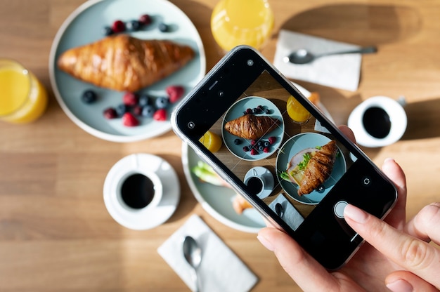 Foto gratuita mujer tomando foto de dos croissants