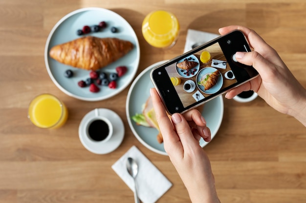 Foto gratuita mujer tomando foto de dos croissants