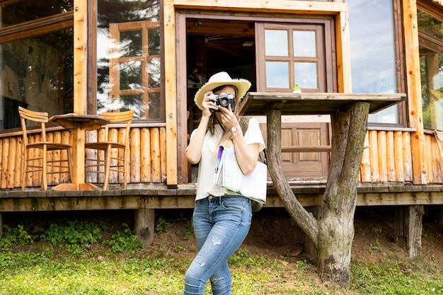 Mujer tomando una foto frente a una casa