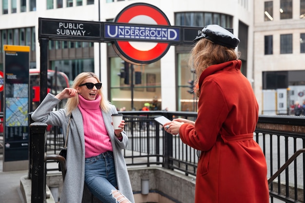 Foto gratuita mujer tomando foto de influencer en la entrada del metro público