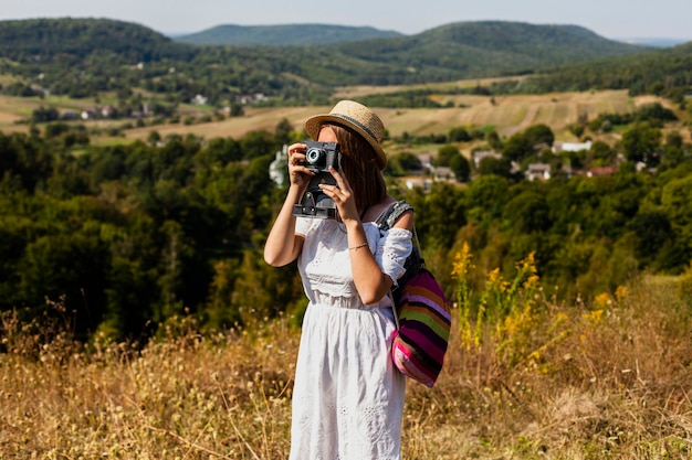 Foto gratuita mujer tomando una foto y llevando su mochila