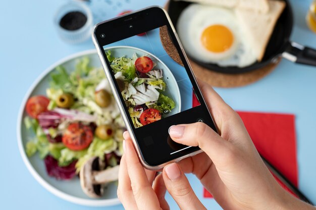 Mujer tomando foto de media ensalada