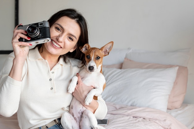 Mujer tomando una foto mientras sostiene el perro
