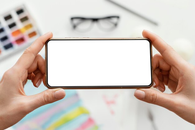 Mujer tomando una foto de su arte con su teléfono