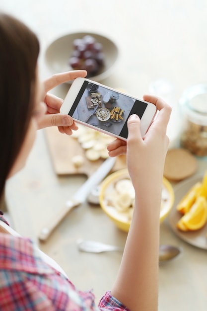 Mujer tomando una foto de su desayuno saludable