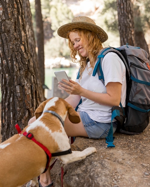 Mujer tomando una foto de su perro en el bosque