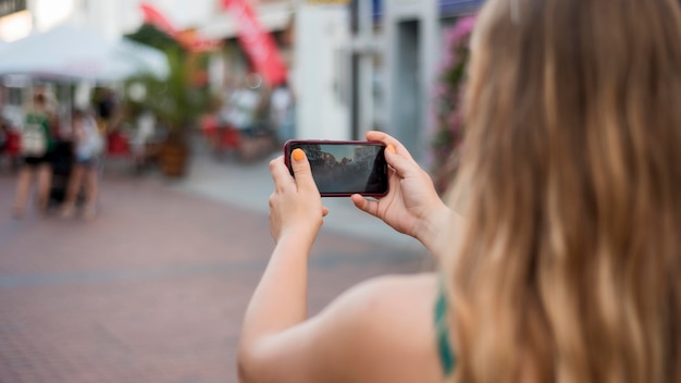 Foto gratuita mujer tomando una foto con su teléfono