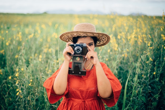 Mujer tomando una fotografía con una cámara antigua