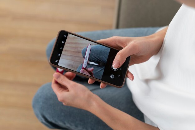 Mujer tomando fotografía de prueba de infertilidad