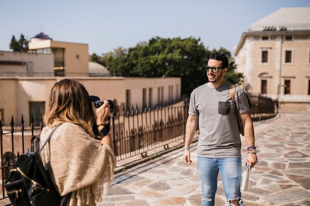 Mujer tomando fotografía de su novio en cámara