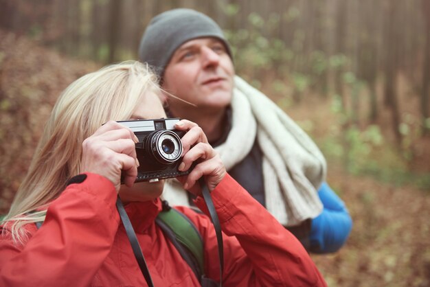 Mujer tomando fotografías en el bosque