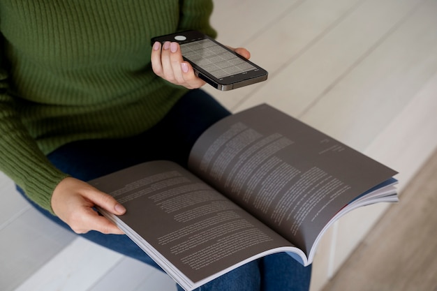 Mujer tomando fotografías de una revista con su smartphone