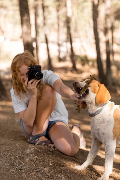 Mujer tomando fotografías de su perro vista larga