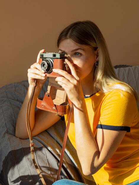 Mujer tomando fotos con una cámara de fotos retro