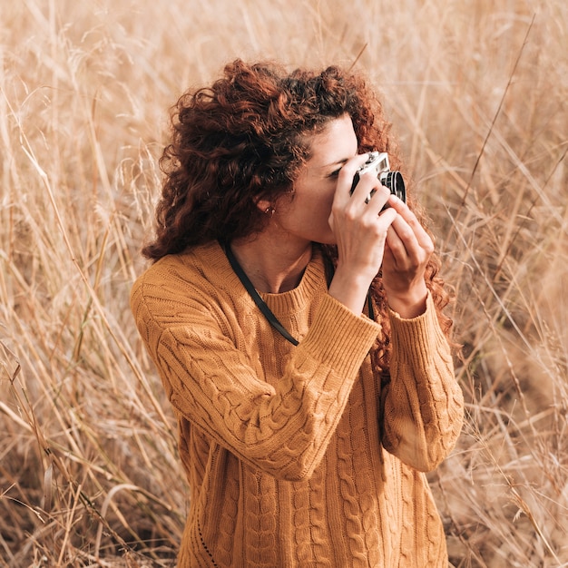 Foto gratuita mujer tomando fotos en el campo de trigo