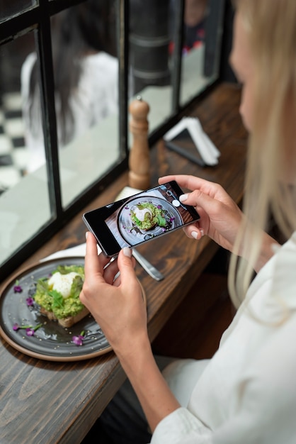 Mujer tomando fotos de comida de cerca