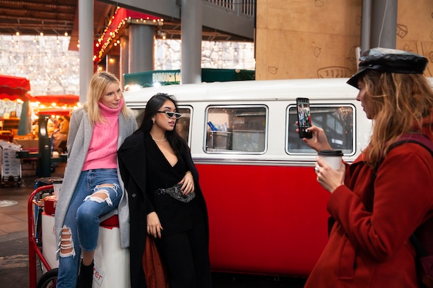 Mujer tomando fotos de dos influencers en el mercado.