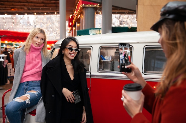 Mujer tomando fotos de dos influencers en el mercado.