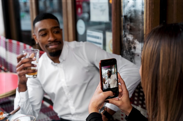 Mujer tomando fotos de hombre sonriente